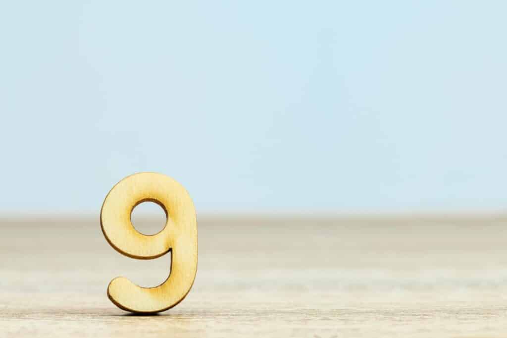 nombre 9 en bois posé sur une table